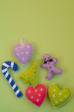 Noel, el yapımı Noel süsleri ya da yeşil yüzeyde izole edilmiş fotokopi alanı olan dekorasyonlar. dikey Yeni Yıl veya yeşil arkaplanda noel selamlaması