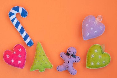 Noel, el yapımı Noel süsleri ya da fotokopi alanı olan neon turuncu yüzeyde izole edilmiş dekorasyonlar. Turuncu arkaplanda yeni yıl veya noel selamlaması