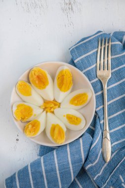 Yumurta, kaynamış yumurta beyaz tabak üzerinde ahşap arka planda veya sağlıklı bir kahvaltı için masa. Ahşap yüzey ya da sırtüstü ketojenik kahvaltı