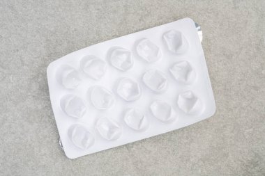 Hap paketi, beyaz kullanılmış boş hap ya da ilaç folyosu ya da gri arka planda su toplaması. Boş ilaç paketi olan eczane kavramı