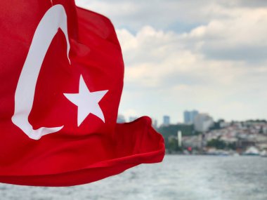 İstanbul, Türkiye 'deki İstanbul deniz ve kent manzarası üzerinde dalgalanan ya da dalgalanan Türk bayrağı. Türkiye Cumhuriyeti ulusal sembolü seçici odaklı