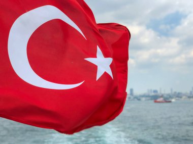 İstanbul, Türkiye 'deki İstanbul deniz ve kent manzarası üzerinde dalgalanan ya da dalgalanan Türk bayrağı. Türkiye Cumhuriyeti ulusal sembolü seçici odaklı