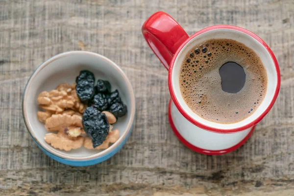 Kahve, bir fincan Türk kahvesi ve ahşap masa, arka plan ya da yüzeyde kurutulmuş meyveler. Türkiye 'nin geleneksel Türk içeceği veya içeceği seçici odaklı masada