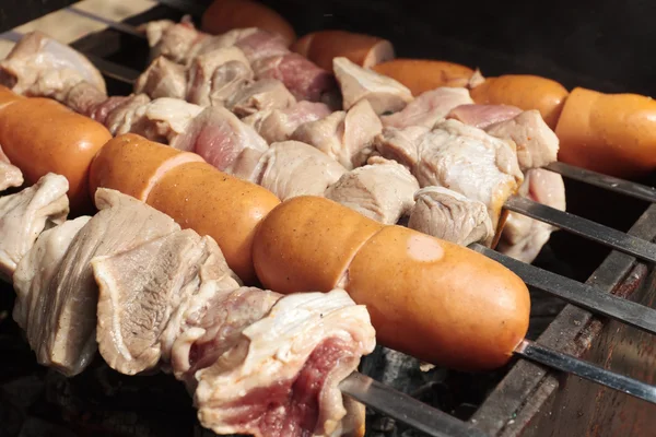 Pork meat and sausages on grill — Stock Photo, Image