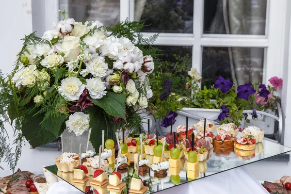 Flowers bouquet and tray canapes — Stock Photo, Image