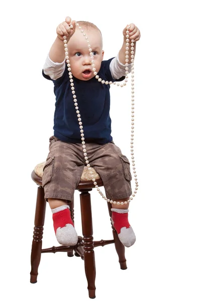 Ragazzo giocando collana di perle — Foto Stock