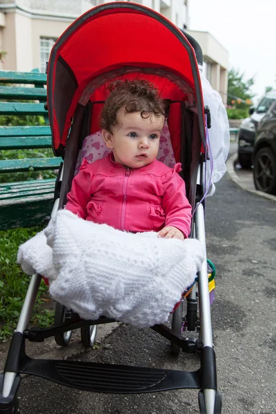 Bebê está sentado no carrinho — Fotografia de Stock