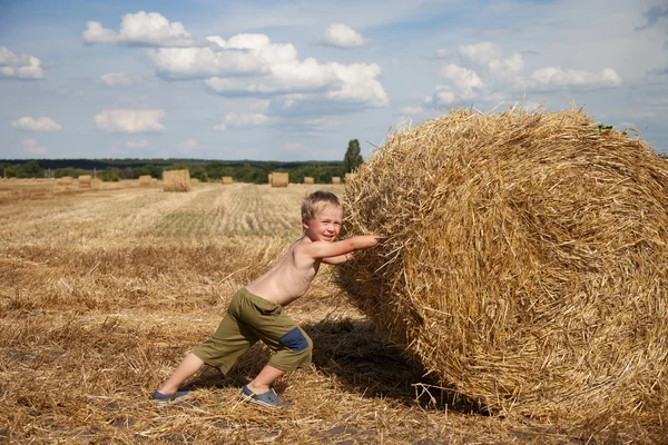 Boy with bale of straw — Stock Photo, Image