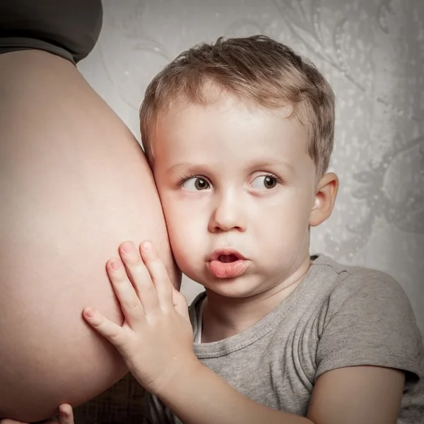 Jongen knuffelen zwangere moeders buik — Stockfoto