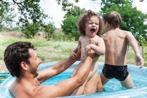 Padre con niños en la piscina — Foto de Stock