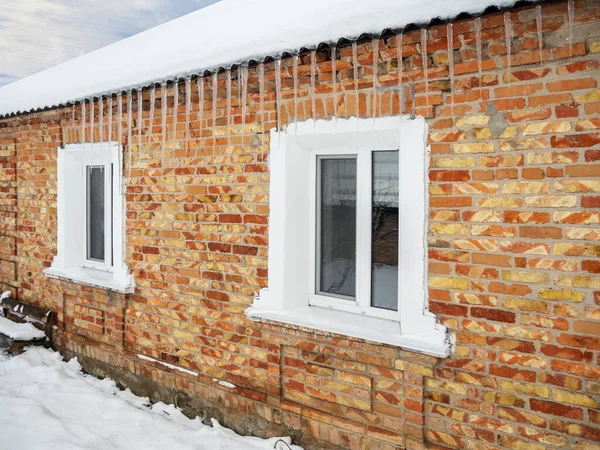 Evin Çatısında Tuğla Duvarın Önünde Buz Saçakları Var — Stok fotoğraf
