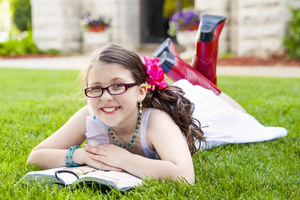 Joven hispana leyendo afuera sonriendo — Foto de Stock