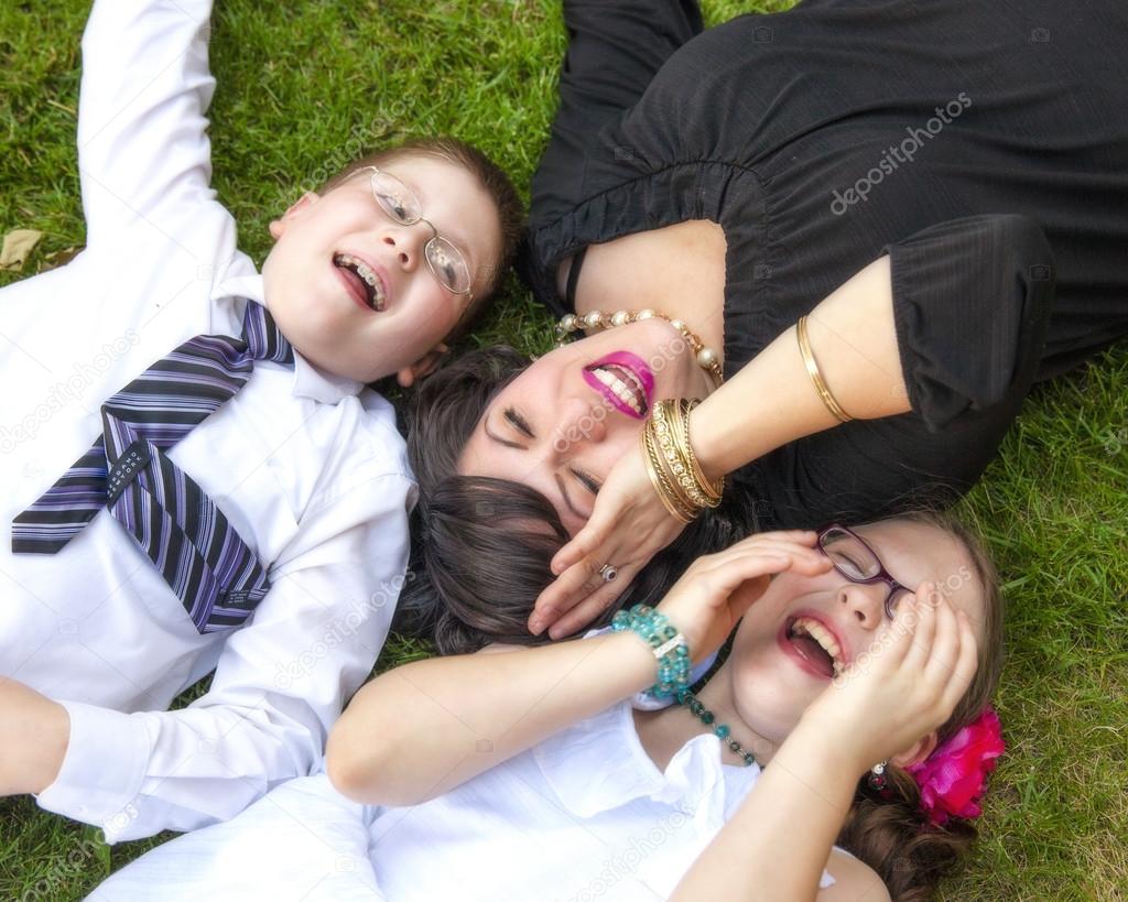 Mother, Son, and Daughter Lauging Outside in the Grass