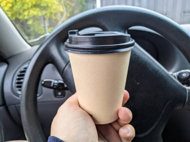 Arabada nefis aromatik kahve var. Fincanı arabaya koy. Elde bardak. Kahveli şoför. Yolculukta bir bardak ve bir içki. Milkshake arabada. 