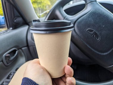 Arabada nefis aromatik kahve var. Fincanı arabaya koy. Elde bardak. Kahveli şoför. Yolculukta bir bardak ve bir içki. Milkshake arabada. 