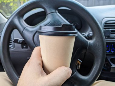 Arabada nefis aromatik kahve var. Fincanı arabaya koy. Elde bardak. Kahveli şoför. Yolculukta bir bardak ve bir içki. Milkshake arabada. 