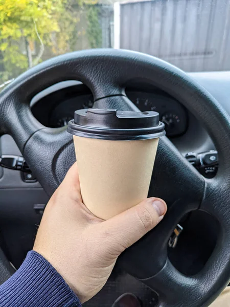 車の中でおいしい香りのコーヒー 車の中でカップ ガラスを手に コーヒーを運転して 旅行中の飲み物付きのガラス 車の中でミルクセーキ — ストック写真