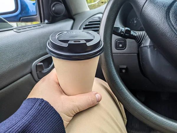 車の中でおいしい香りのコーヒー 車の中でカップ ガラスを手に コーヒーを運転して 旅行中の飲み物付きのガラス 車の中でミルクセーキ — ストック写真