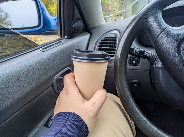 車の中でおいしい香りのコーヒー 車の中でカップ ガラスを手に コーヒーを運転して 旅行中の飲み物付きのガラス 車の中でミルクセーキ — ストック写真