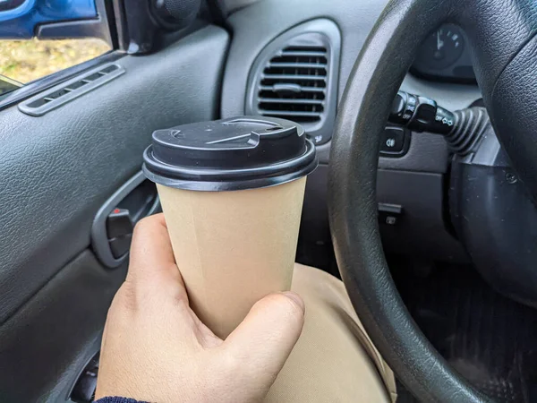 車の中でおいしい香りのコーヒー 車の中でカップ ガラスを手に コーヒーを運転して 旅行中の飲み物付きのガラス 車の中でミルクセーキ — ストック写真