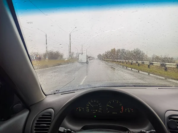 雨点落在汽车的玻璃上 把车开到门口去 在恶劣的天气下旅行 方向盘后面的司机 — 图库照片