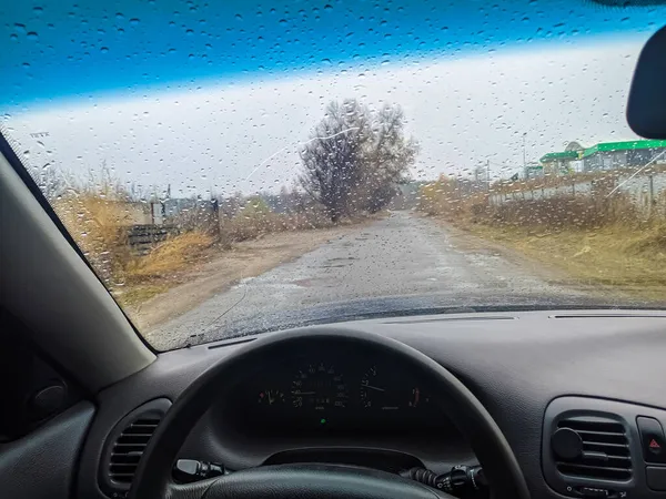 雨点落在汽车的玻璃上 把车开到门口去 在恶劣的天气下旅行 方向盘后面的司机 — 图库照片