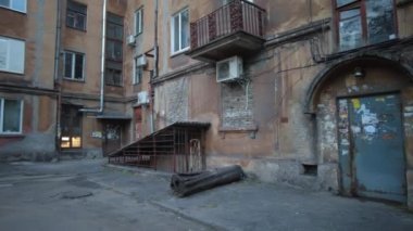 Modern yerleşim alanı olan şehir manzarası, yeni apartmanlar ve sonbaharda yaya geçidi ve ağaçları olan yeşil avlu. Bahçede sonbahar yaprakları. Eski evin avlusunda yürü.