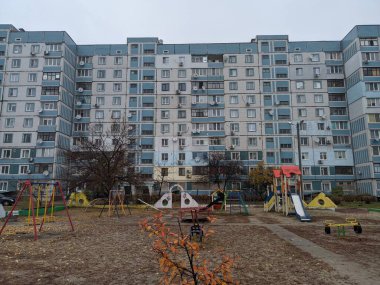 Çok katlı bir binada oyun parkı. Çocuk atlıkarıncaları oyun bahçesinde. Sovyet oyun parkı. Çok katlı Sovyet evleri. Anaokulu slaytları ve atlı karıncalar. Çocuklarla Tatil. 