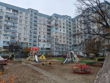 Çok katlı bir binada oyun parkı. Çocuk atlıkarıncaları oyun bahçesinde. Sovyet oyun parkı. Çok katlı Sovyet evleri. Anaokulu slaytları ve atlı karıncalar. Çocuklarla Tatil. 