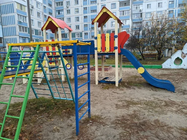Çok katlı bir binada oyun parkı. Çocuk atlıkarıncaları oyun bahçesinde. Sovyet oyun parkı. Çok katlı Sovyet evleri. Anaokulu slaytları ve atlı karıncalar. Çocuklarla Tatil. 