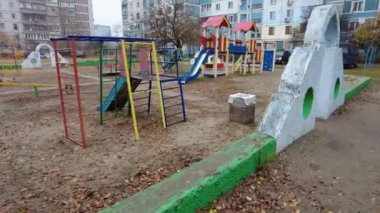 Çok katlı bir binada oyun parkı. Çocuk atlıkarıncaları oyun bahçesinde. Sovyet oyun parkı. Çok katlı Sovyet evleri. Anaokulu slaytları ve atlı karıncalar. Çocuklarla Tatil. 
