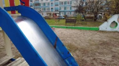 Çok katlı bir binada oyun parkı. Çocuk atlıkarıncaları oyun bahçesinde. Sovyet oyun parkı. Çok katlı Sovyet evleri. Anaokulu slaytları ve atlı karıncalar. Çocuklarla Tatil. 