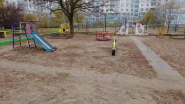 Çok katlı bir binada oyun parkı. Çocuk atlıkarıncaları oyun bahçesinde. Sovyet oyun parkı. Çok katlı Sovyet evleri. Anaokulu slaytları ve atlı karıncalar. Çocuklarla Tatil. 