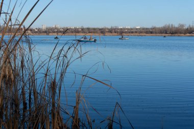 Teknelerdeki balıkçılar. Göl manzaralı. Nehrin mavi suyu. Elinde olta olan bir balıkçı. balıkçılık. 