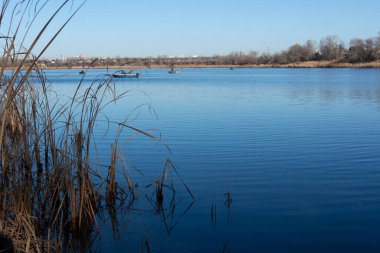 Teknelerdeki balıkçılar. Göl manzaralı. Nehrin mavi suyu. Elinde olta olan bir balıkçı. balıkçılık. 