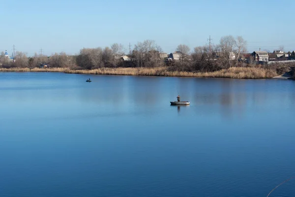漁船の漁師だ 湖のある風景 川の青い水だ 釣り竿を持った漁師 — ストック写真