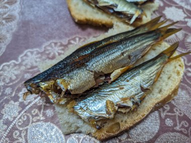 Tütsülenmiş balık. Lezzetli küçük balıklar. Deniz ürünleri. Balıklı sandviç. altın balık