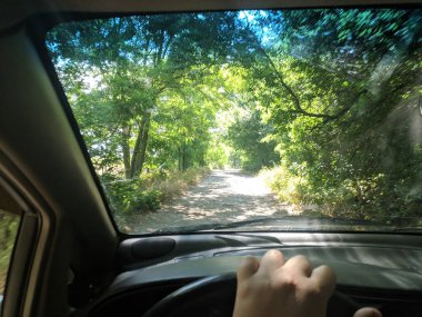 Arabanın içinde. Şoför direksiyonda. Araba kullanmak. Yolculuk. Kötü yollar. Arabayla. Direksiyon ve gösterge paneli. tekerlekler ve motorlar. 