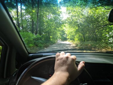 Arabanın içinde. Şoför direksiyonda. Araba kullanmak. Yolculuk. Kötü yollar. Arabayla. Direksiyon ve gösterge paneli. tekerlekler ve motorlar. 