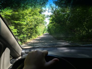 Arabanın içinde. Şoför direksiyonda. Araba kullanmak. Yolculuk. Kötü yollar. Arabayla. Direksiyon ve gösterge paneli. tekerlekler ve motorlar. 