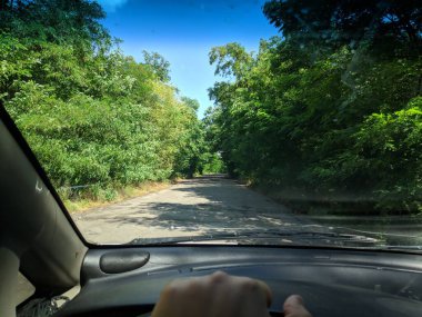 Arabanın içinde. Şoför direksiyonda. Araba kullanmak. Yolculuk. Kötü yollar. Arabayla. Direksiyon ve gösterge paneli. tekerlekler ve motorlar. 