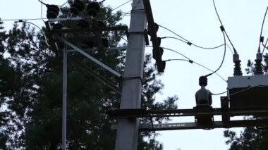 Güç iletim hatları. Elektrik direkleri ve telleri. Günbatımında yüksek voltajlı elektrik hatları, yüksek voltajlı elektrik iletim kulesi. Yüksek voltaj kuleleri uzak mesafeden enerji sağlıyor..