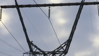 Güç iletim hatları. Elektrik direkleri ve telleri. Günbatımında yüksek voltajlı elektrik hatları, yüksek voltajlı elektrik iletim kulesi. Yüksek voltaj kuleleri uzak mesafeden enerji sağlıyor..
