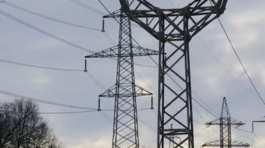 Güç iletim hatları. Elektrik direkleri ve telleri. Günbatımında yüksek voltajlı elektrik hatları, yüksek voltajlı elektrik iletim kulesi. Yüksek voltaj kuleleri uzak mesafeden enerji sağlıyor..