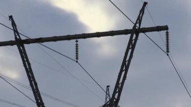 Güç iletim hatları. Elektrik direkleri ve telleri. Günbatımında yüksek voltajlı elektrik hatları, yüksek voltajlı elektrik iletim kulesi. Yüksek voltaj kuleleri uzak mesafeden enerji sağlıyor..