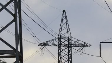 Güç iletim hatları. Elektrik direkleri ve telleri. Günbatımında yüksek voltajlı elektrik hatları, yüksek voltajlı elektrik iletim kulesi. Yüksek voltaj kuleleri uzak mesafeden enerji sağlıyor..