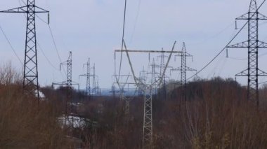 Güç iletim hatları. Elektrik direkleri ve telleri. Günbatımında yüksek voltajlı elektrik hatları, yüksek voltajlı elektrik iletim kulesi. Yüksek voltaj kuleleri uzak mesafeden enerji sağlıyor..