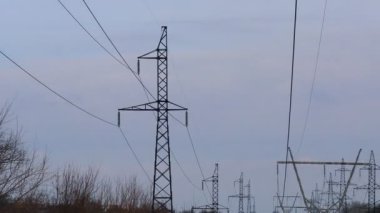 Güç iletim hatları. Elektrik direkleri ve telleri. Günbatımında yüksek voltajlı elektrik hatları, yüksek voltajlı elektrik iletim kulesi. Yüksek voltaj kuleleri uzak mesafeden enerji sağlıyor..