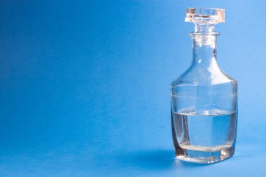 Suyla şeffaf sürahi. Sürahide votka. Sürahide votka ve masada yansıması olan bir bardak. Antika cam eşyalar. Kırılgan madde. İzole edilmiş beyaz arkaplanda nesneler.