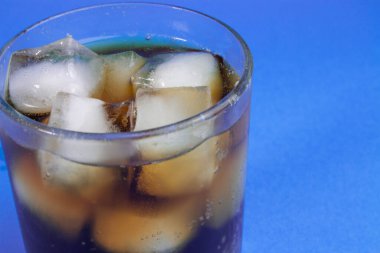Kola ve buz bir bardakta. Karbonatlı içecek. Beyaza izole edilmiş buzlu tatlı karbonatlı içecekler. Kırpma yolu ile. Buzlu ve köpüklü kolanın arka planı.